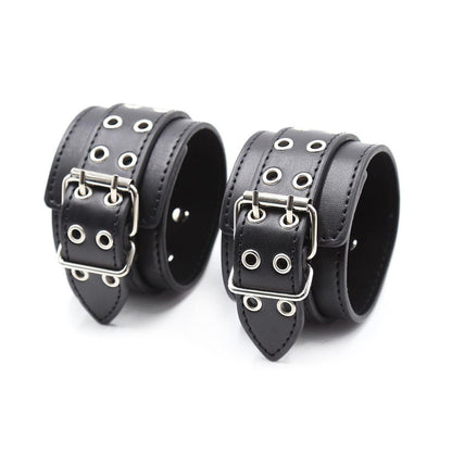 Pair of black BDSM cuffs with metal eyelets