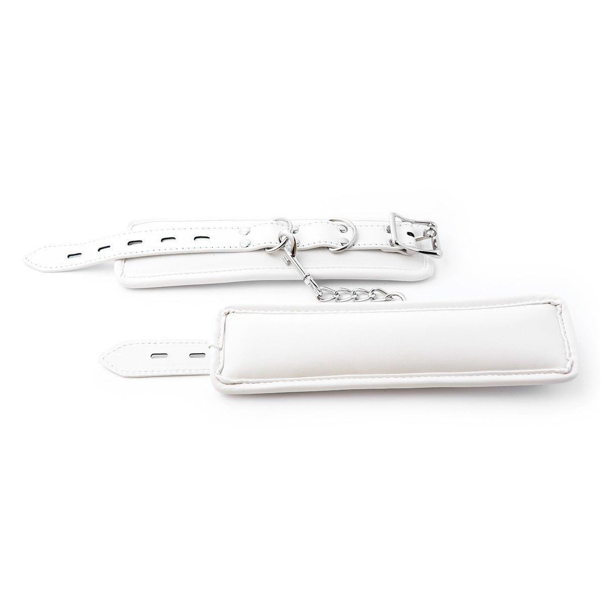 White BDSM wrist restraints with silver chain